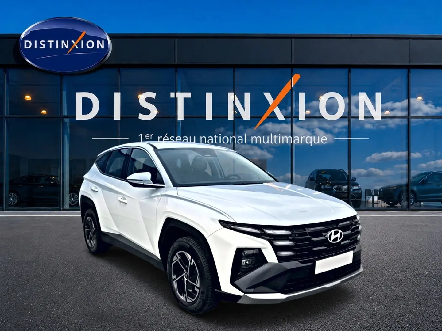 Hyundai Tucson blanc en 3/4 avant droit, avec calandre noire distinctive et jantes alliage 17 pouces.