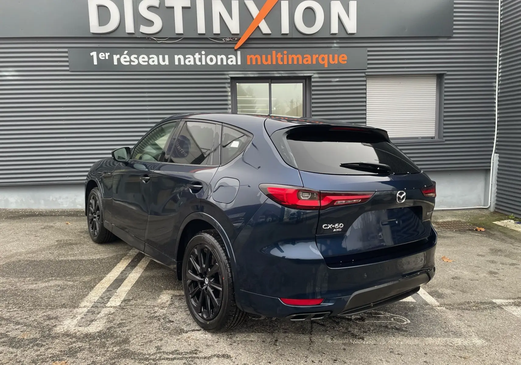 Vue 3/4 arrière gauche du Mazda CX-60 Deep Crystal Blue avec jantes noires et feux arrière LED distinctifs.