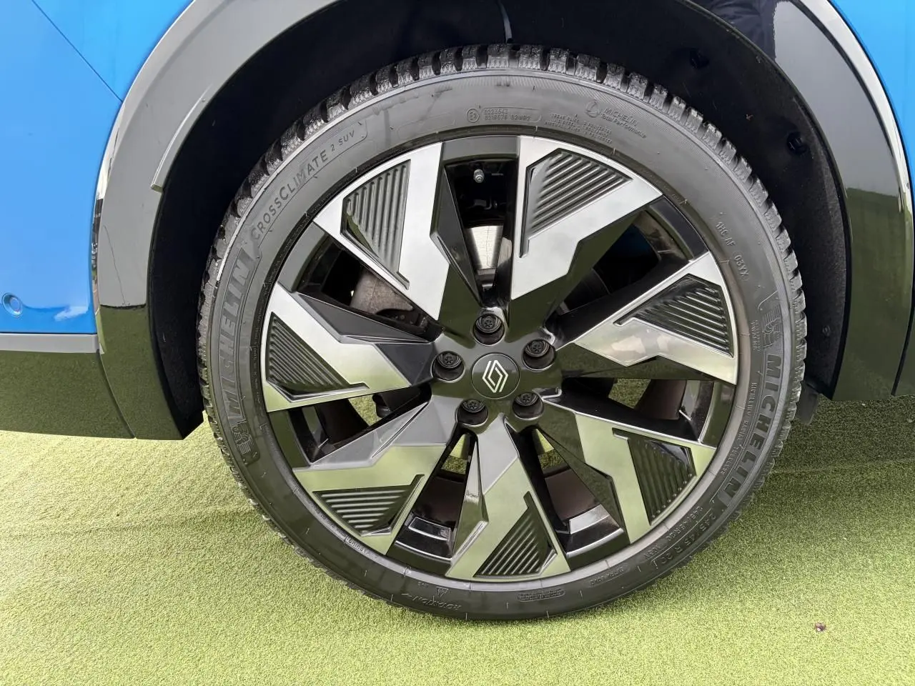 Gros plan sur la jante alliage noire et argentée du côté gauche d’un Renault Rafale Summit Blue.