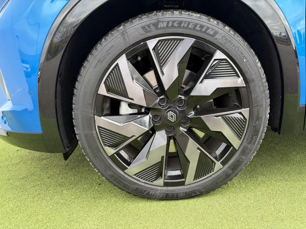 Gros plan sur la jante alliage noire et argentée du côté gauche d’un Renault Rafale Summit Blue.