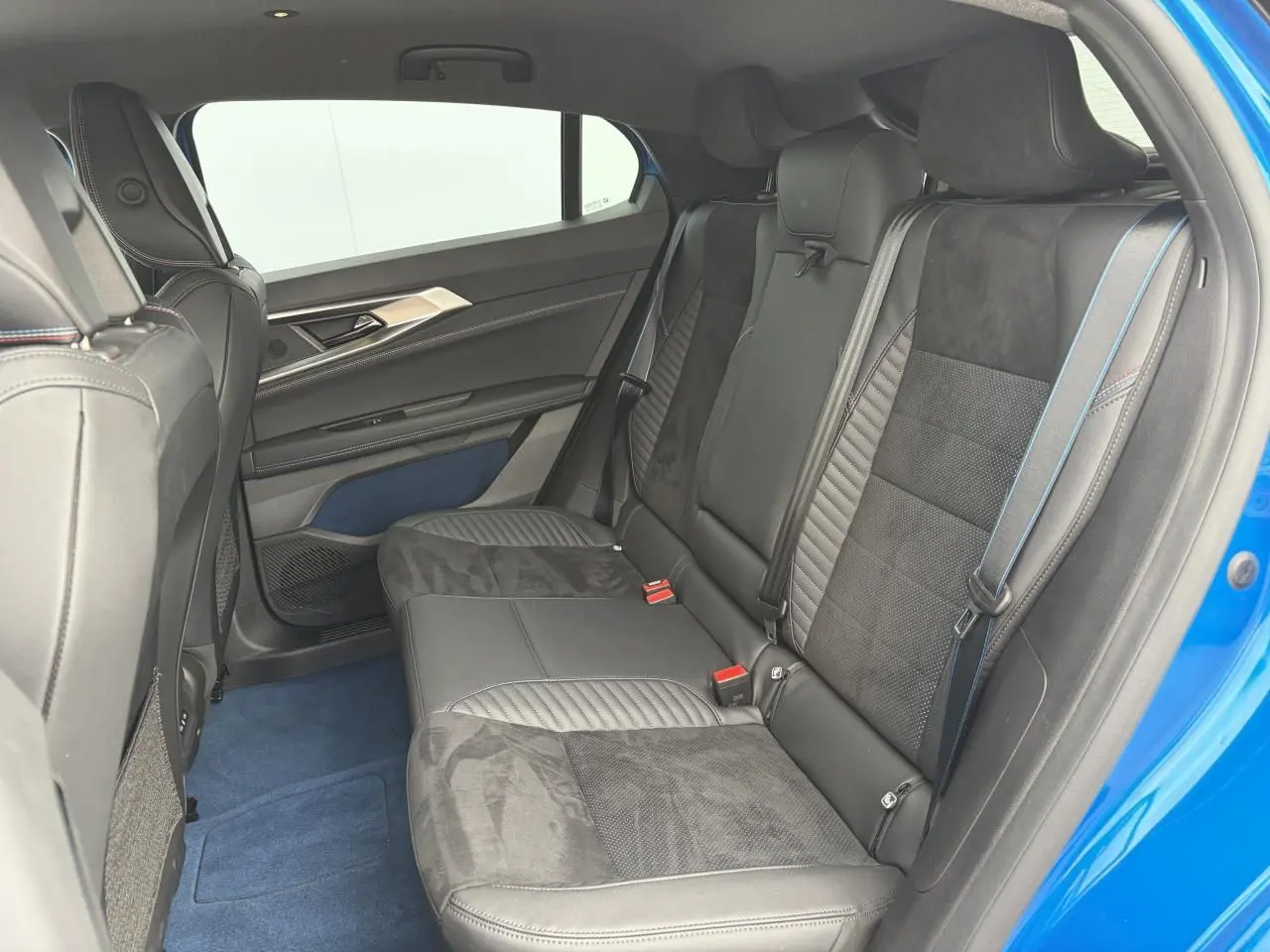 Vue intérieure côté droit des sièges arrière en Alcantara noir avec surpiqûres bleues du Renault Rafale Summit Blue 2025.