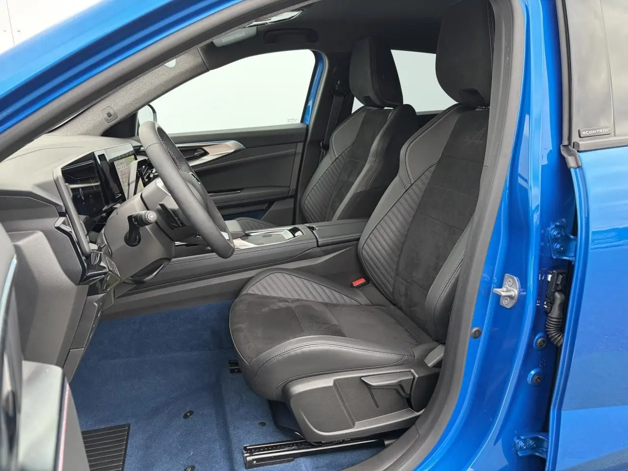 Vue intérieure côté conducteur de la Renault Rafale Summit Blue 2025 avec sièges sport en Alcantara noir.