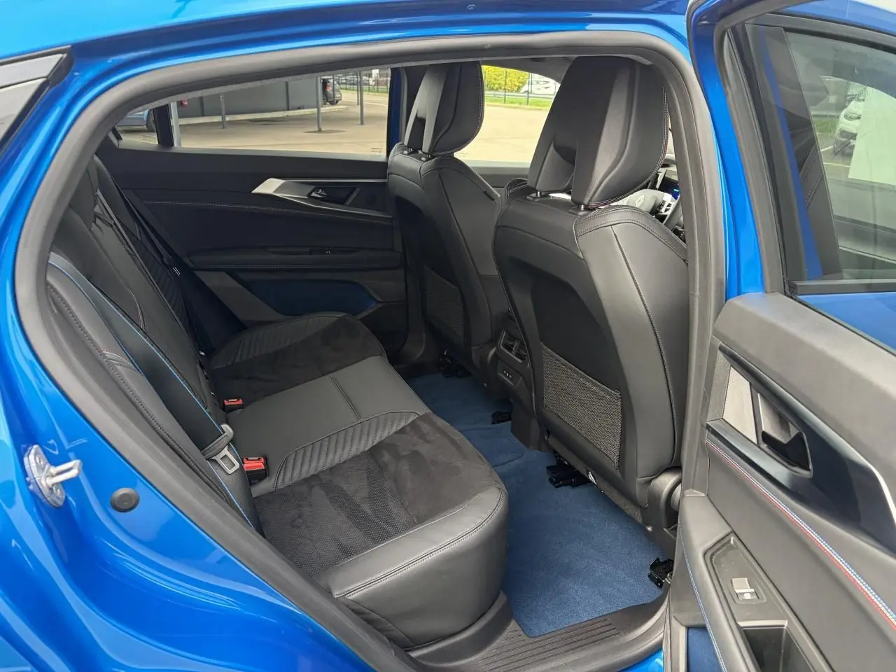 Vue côté gauche de l'habitacle arrière bleu Summit avec sièges en Alcantara noir et surpiqûres tricolores.