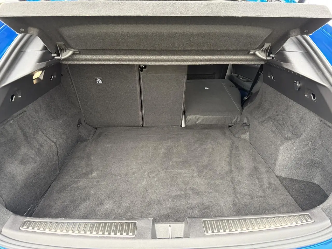 Coffre ouvert vu de l'arrière d'une Renault Rafale Summit Blue avec banquette arrière partiellement rabattue.