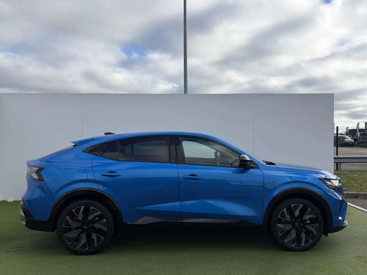 Profil droit du Renault Rafale 2025 hybride rechargeable en bleu Summit avec jantes noires diamantées.