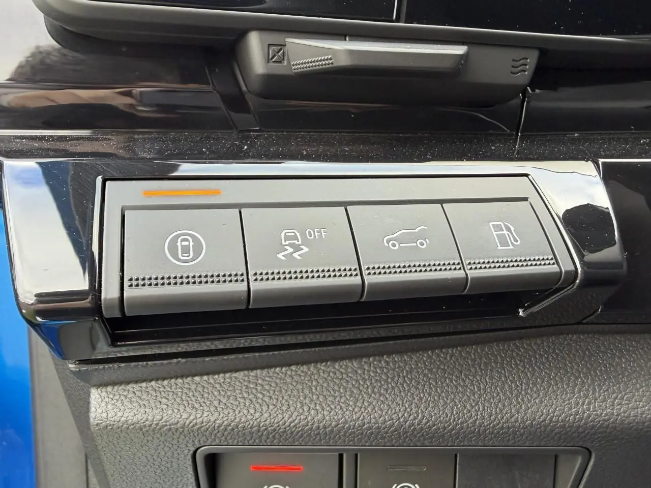 Gros plan sur les boutons de commande gris dans l'habitacle du Renault Rafale 2025 Summit Blue, avec finition noire brillante.