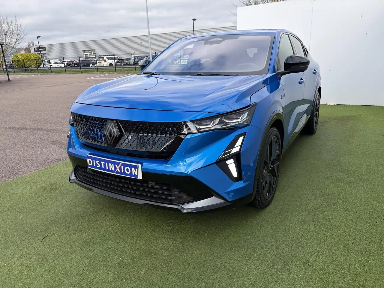 Renault Rafale Summit Blue vue 3/4 avant droit, avec calandre noire et jantes alliage noires.