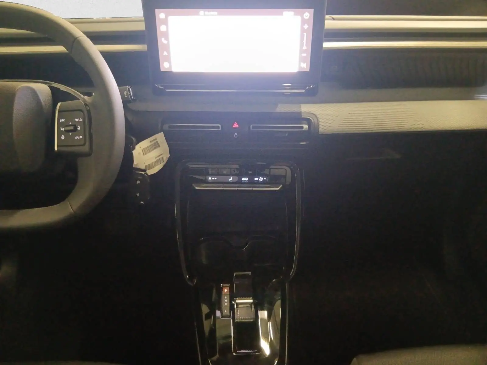 Vue intérieure centrée sur la console et volant du Citroën C3 Aircross hybride 2025 avec écran tactile lumineux.