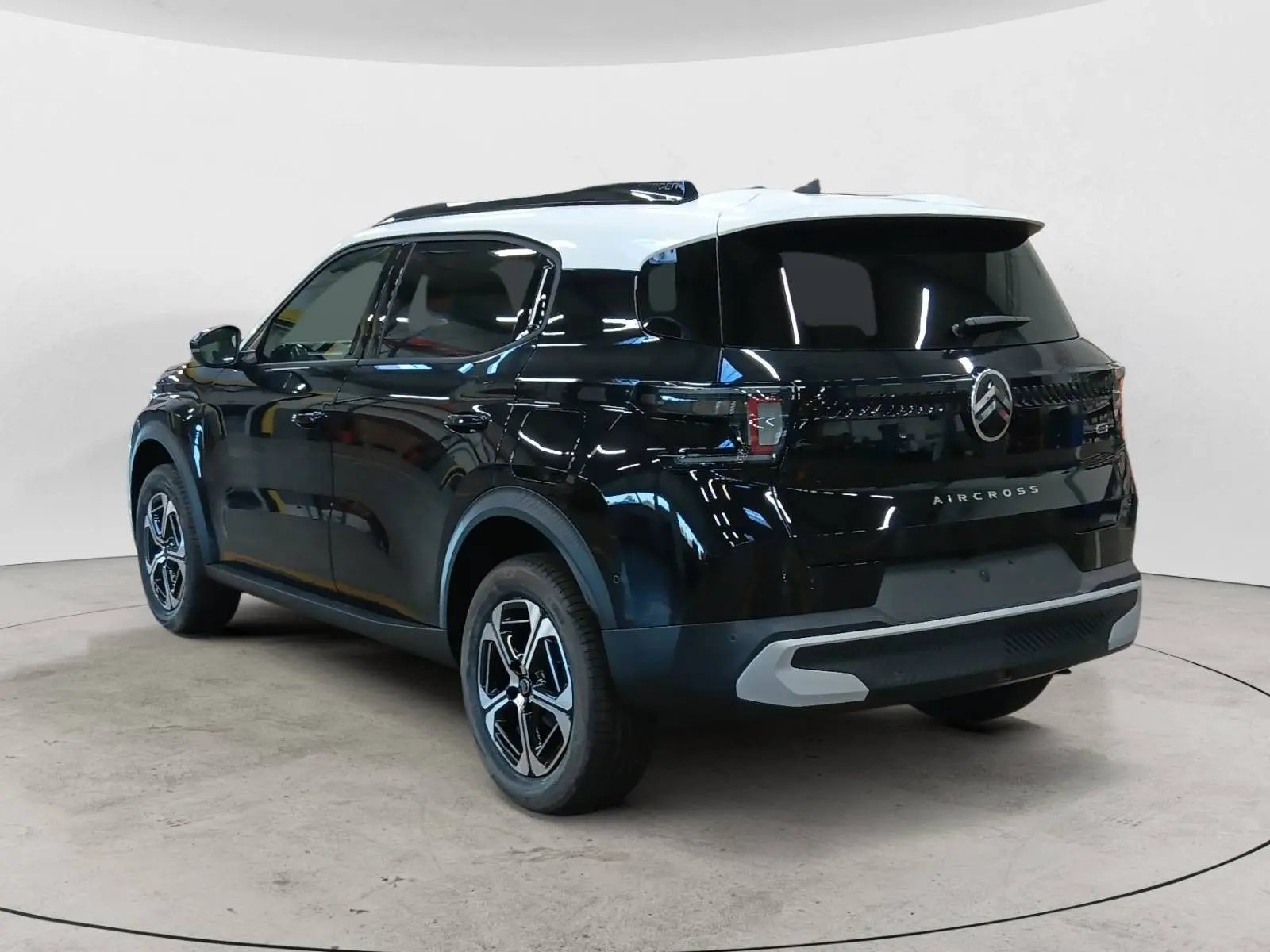 Vue 3/4 arrière droite du Citroën C3 Aircross 2025 noir perla avec toit blanc et jantes bicolores distinctives.