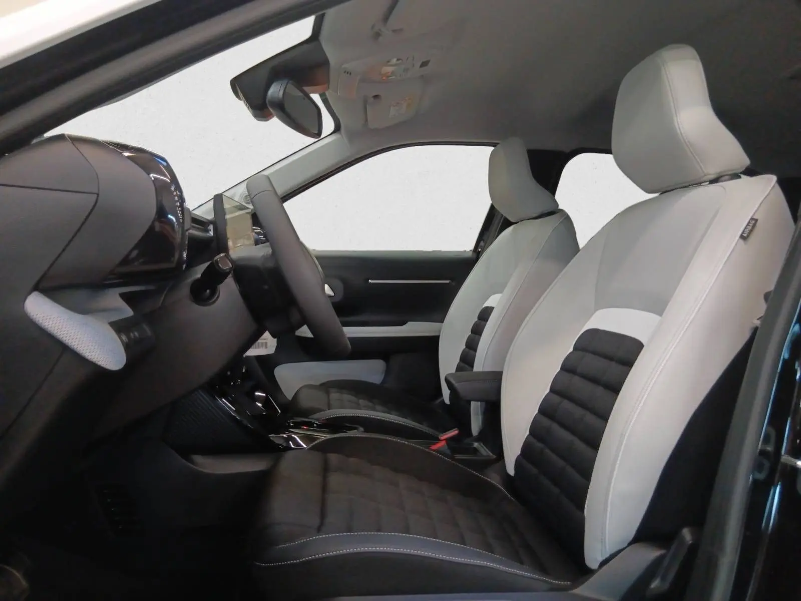 Vue intérieure côté conducteur du Citroën C3 Aircross 2025, sièges Advanced Comfort bi-ton noir et blanc.