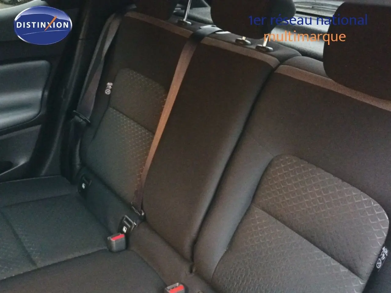 Vue rapprochée des sièges arrière noirs du Nissan Juke gris platine, mettant en valeur les ceintures de sécurité.