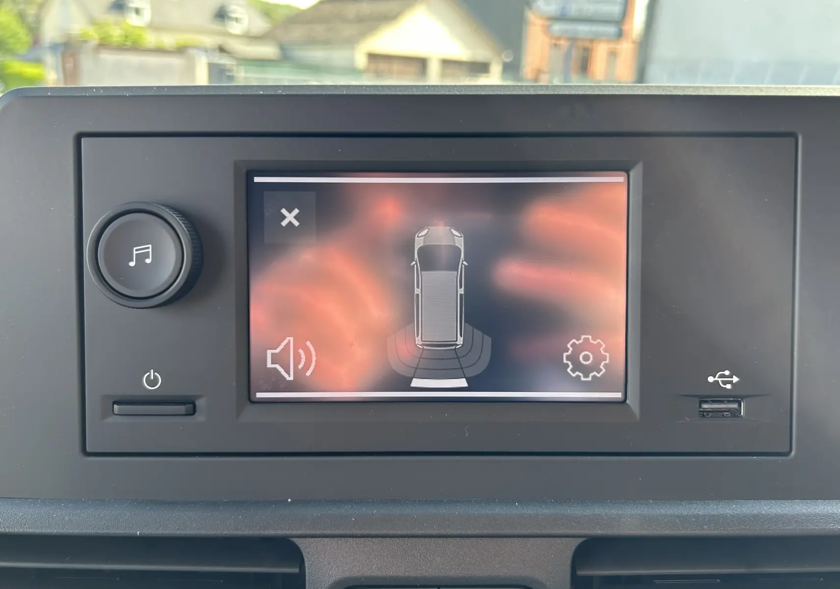 Écran tactile intérieur du Peugeot Partner Dangel 4x4 montrant l'alerte de détection d'obstacle arrière.