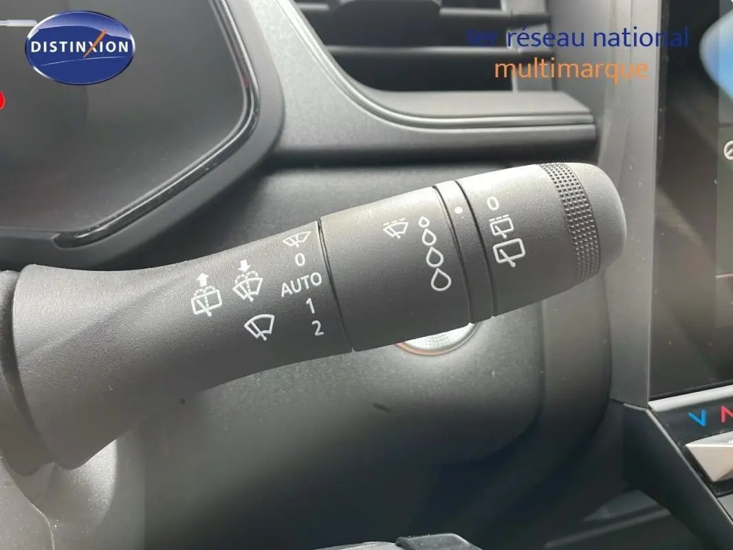 Gros plan sur la commande d’essuie-glace du Renault Captur gris 2025, avec tableau de bord et écran tactile en arrière-plan.