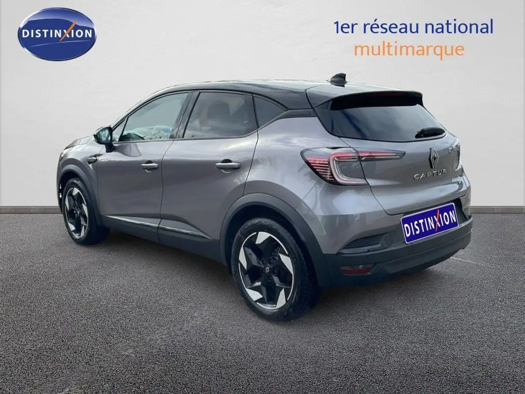 Vue 3/4 arrière droite d'un Renault Captur gris 2025 avec jantes aluminium 18 pouces et toit noir contrasté.