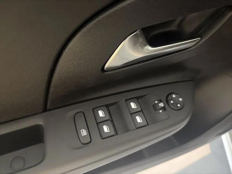 Détail de la commande des vitres et rétroviseurs côté conducteur de l’Opel Corsa gris 2025, intérieur noir.