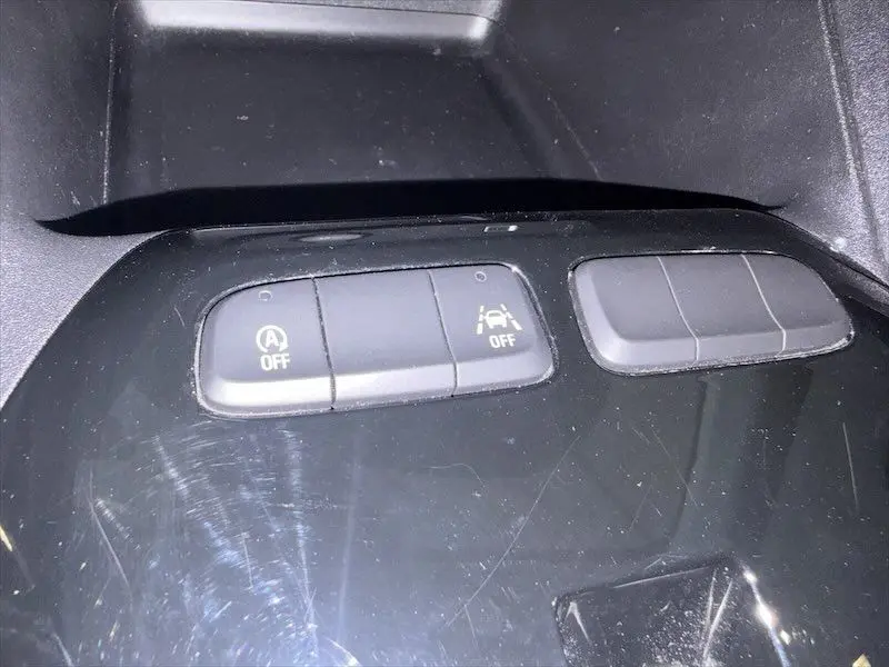 Gros plan sur les boutons de commande du système Start/Stop et de l'assistance au maintien de voie dans une Opel Corsa gris 2025.