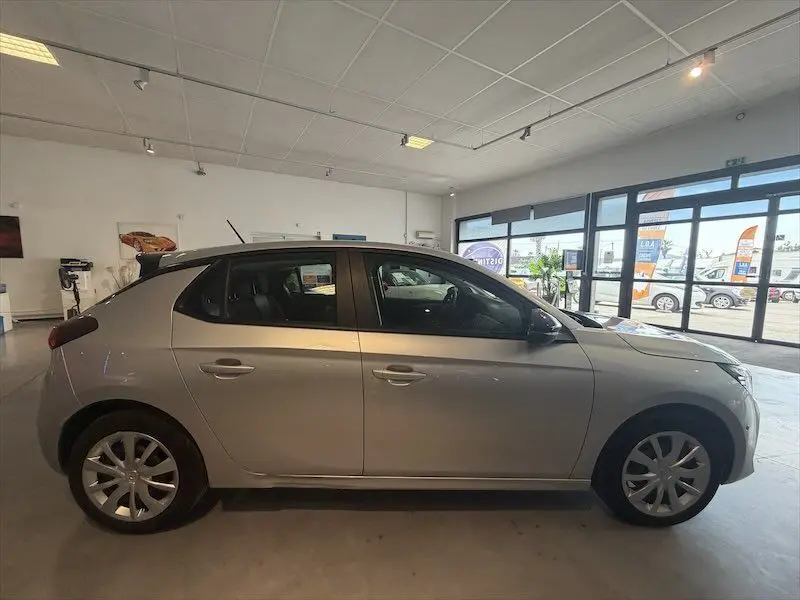 Vue latérale droite d'une Opel Corsa 2025 gris clair, exposée en intérieur avec jantes alliage et lignes épurées.