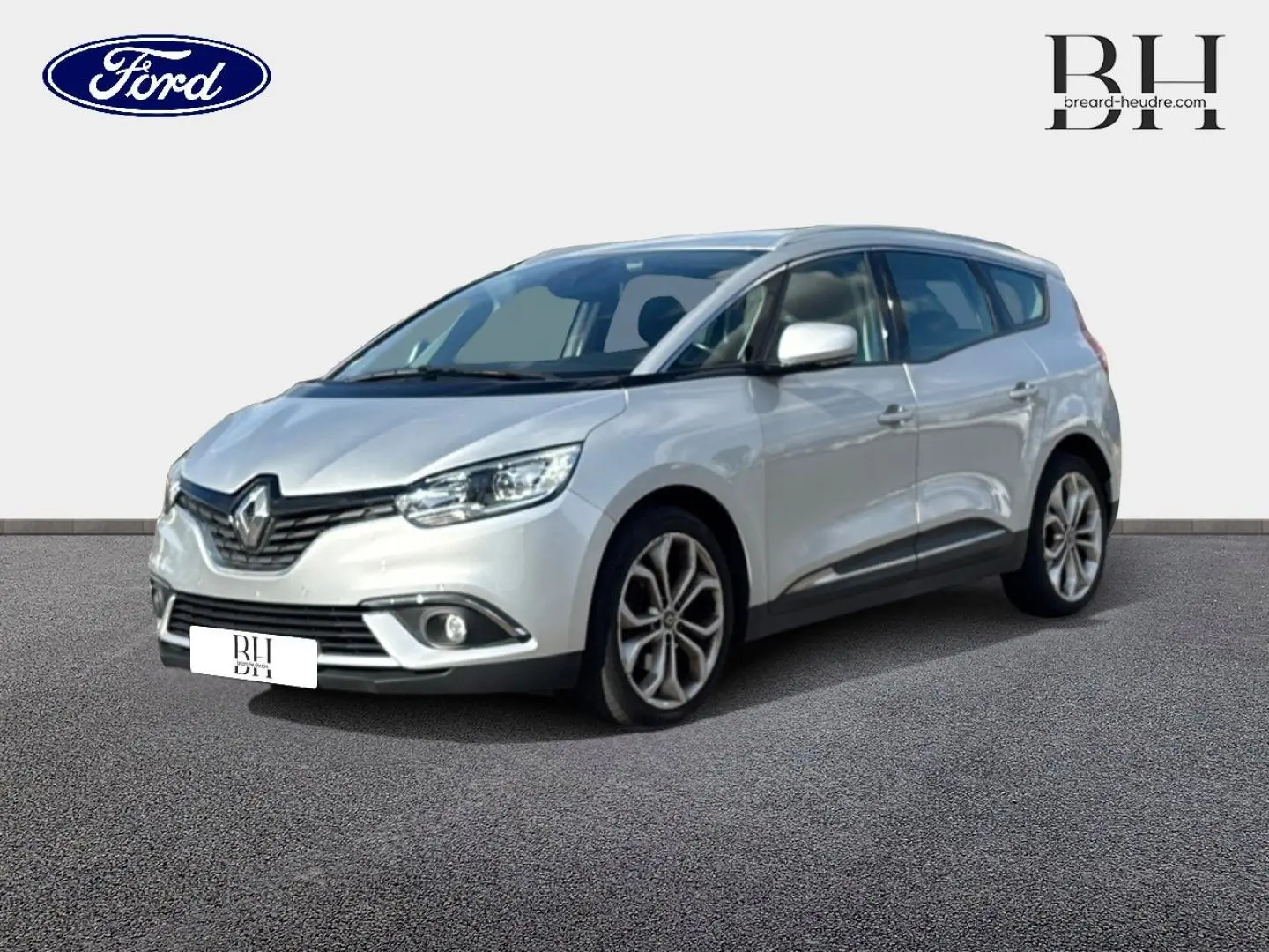 Renault Grand Scenic gris platine vu en 3/4 avant droit, avec jantes alliage et feux LED allumés.