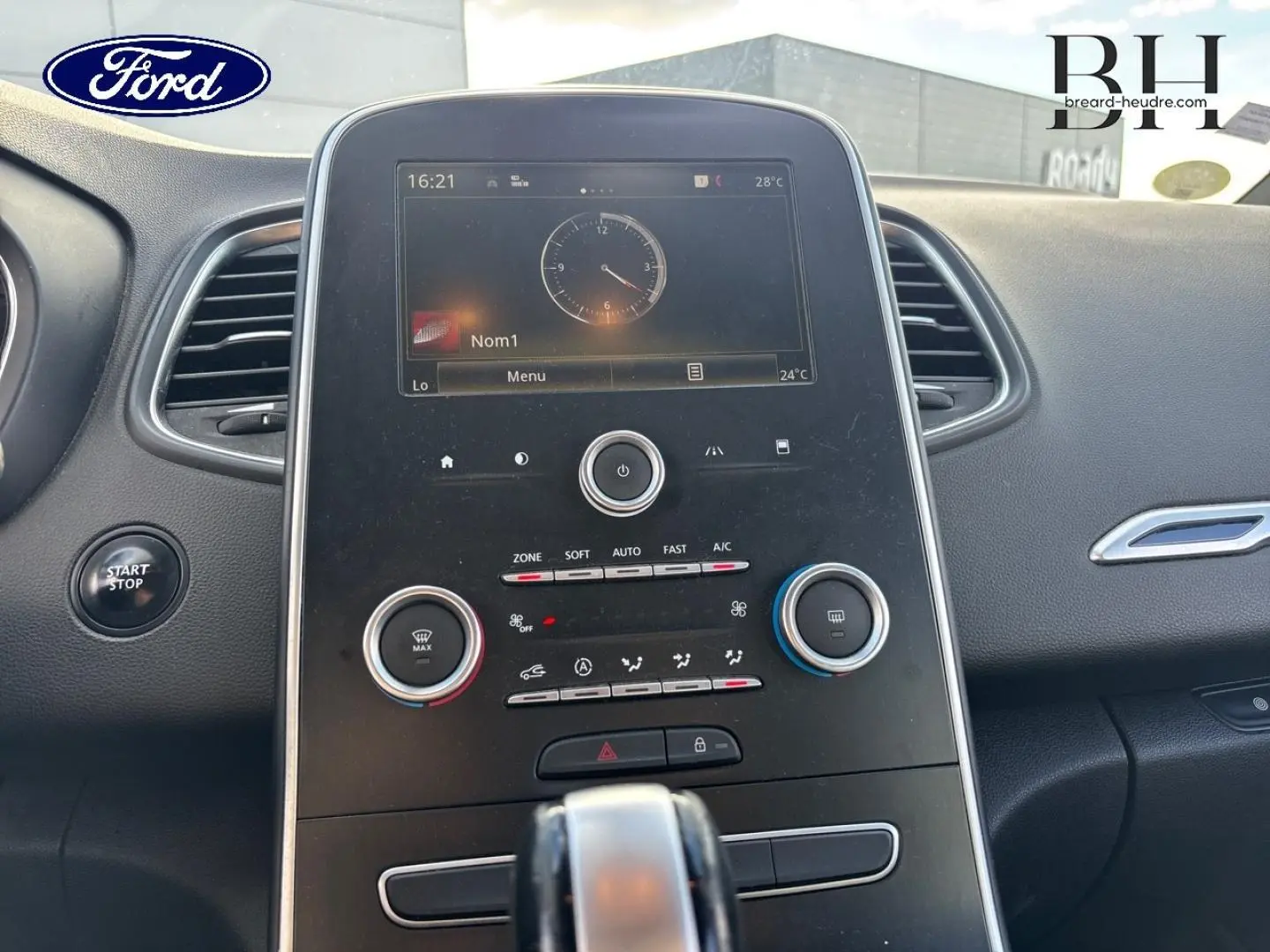 Vue rapprochée du tableau de bord central du Renault Grand Scenic 2017 gris platine, avec écran tactile et commandes climatiques.