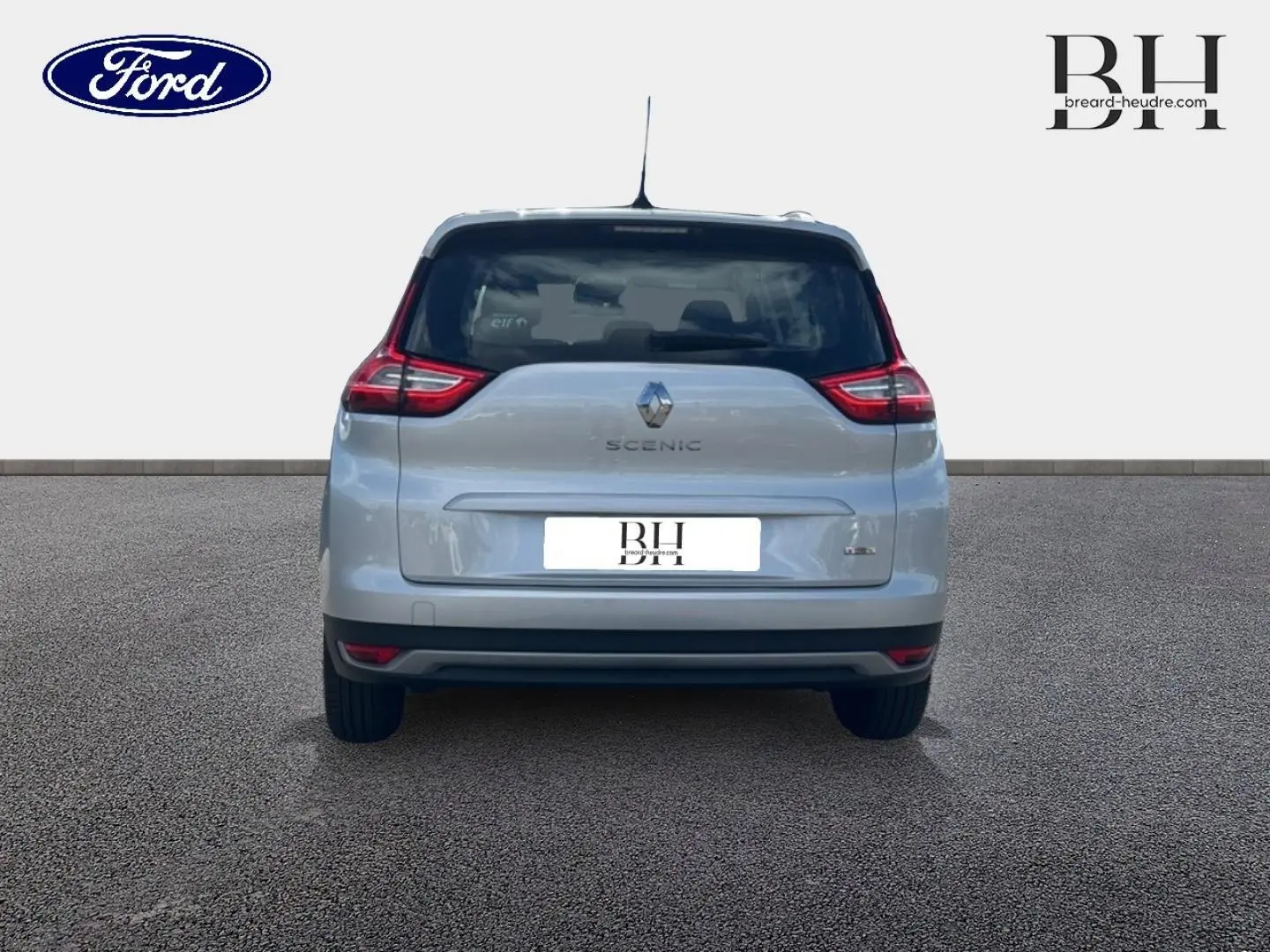 Vue arrière d'un Renault Grand Scenic gris platine, mettant en valeur ses feux arrière distinctifs et son logo central.