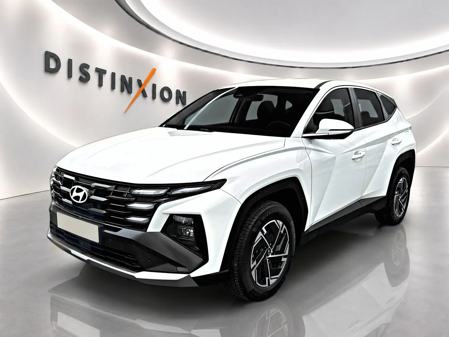 Hyundai Tucson 1.6 T-GDI hybride blanc en 3/4 avant droit, avec calandre noire et jantes alliage 17 pouces.