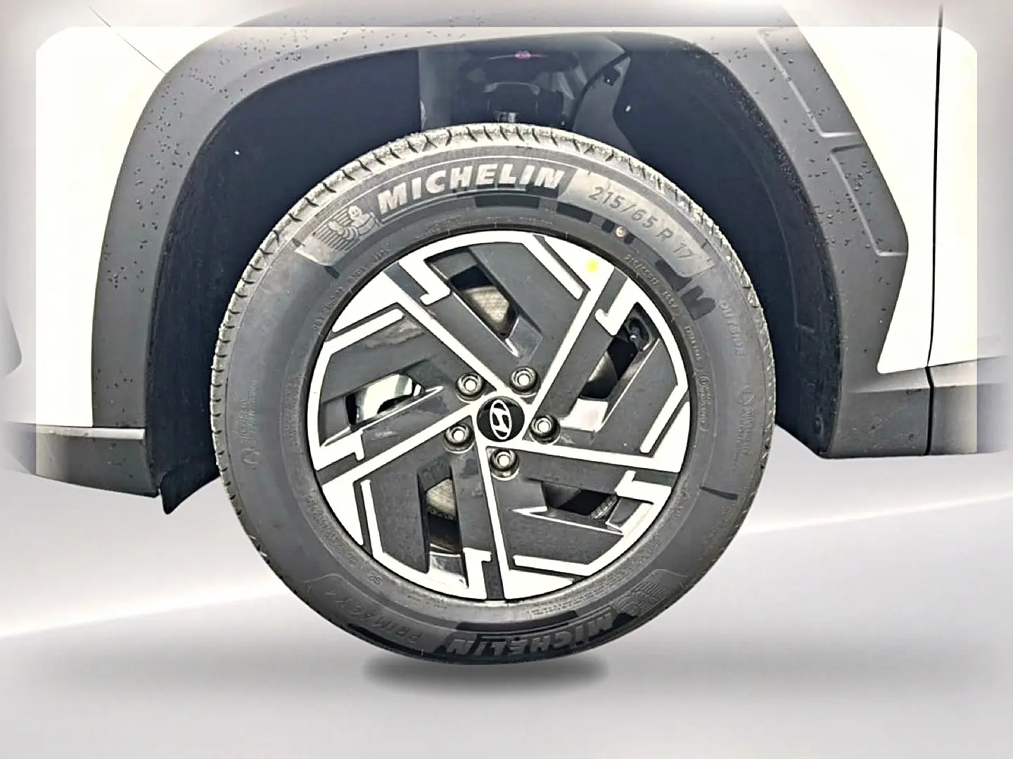 Gros plan sur la roue avant gauche blanche d’un Hyundai Tucson 1.6 T-GDI hybride avec jante alliage 17 pouces et pneu Michelin.