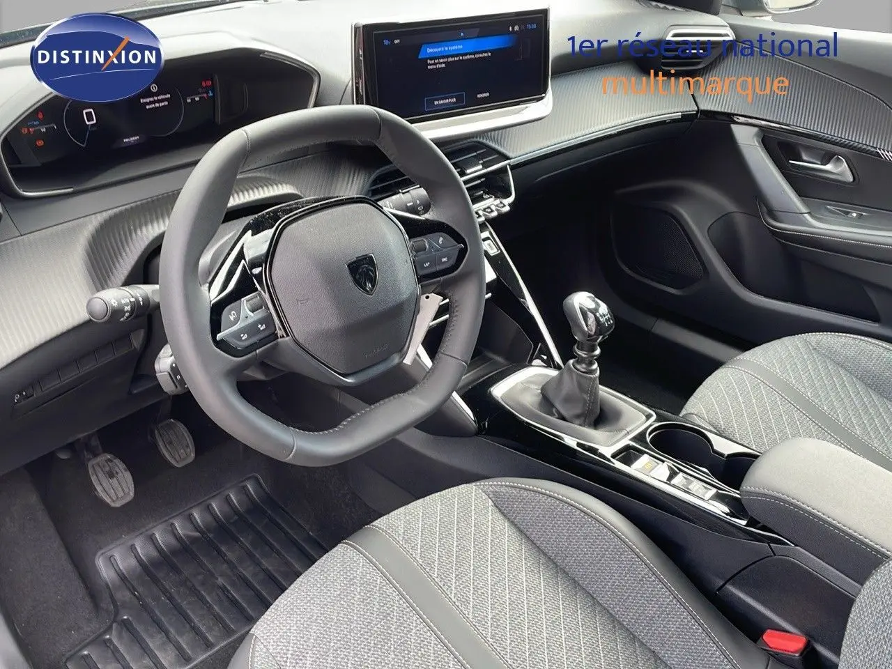 Intérieur du Peugeot 2008 2025 côté conducteur, volant compact, tableau de bord numérique et sellerie tissu gris.