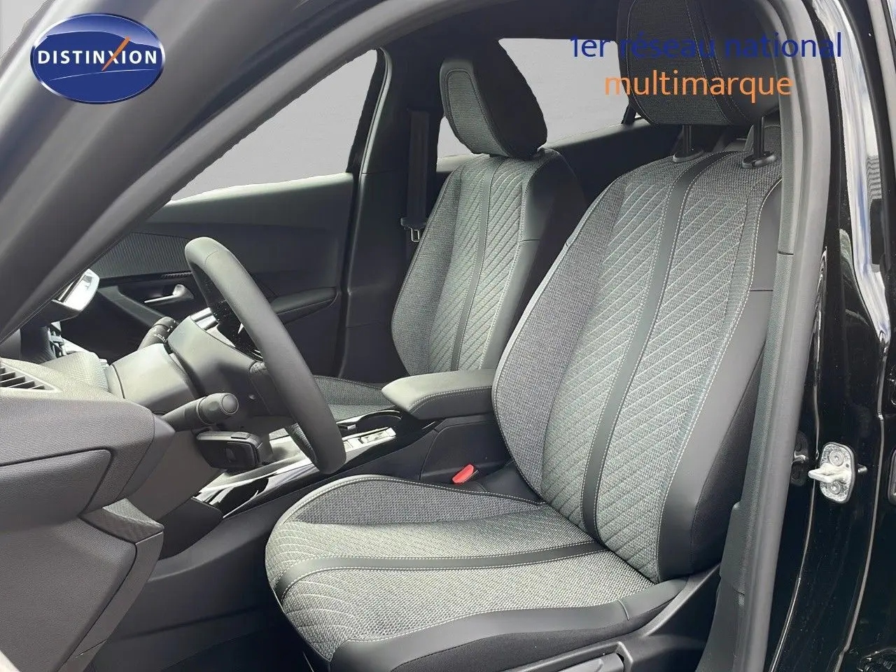 Intérieur de la Peugeot 2008 2025 en noir perla métal, vue côté conducteur sur les sièges tissu et cuir gris.