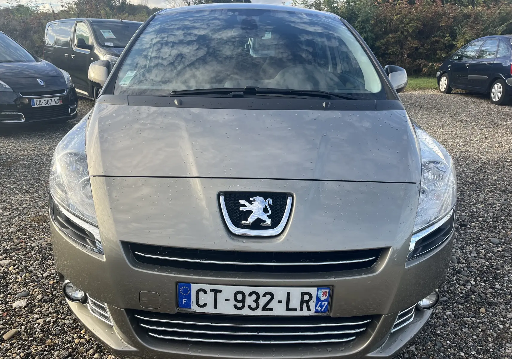 Vue frontale d'un Peugeot 5008 gris métallisé 2013 avec logo lion et plaque d'immatriculation française visible.