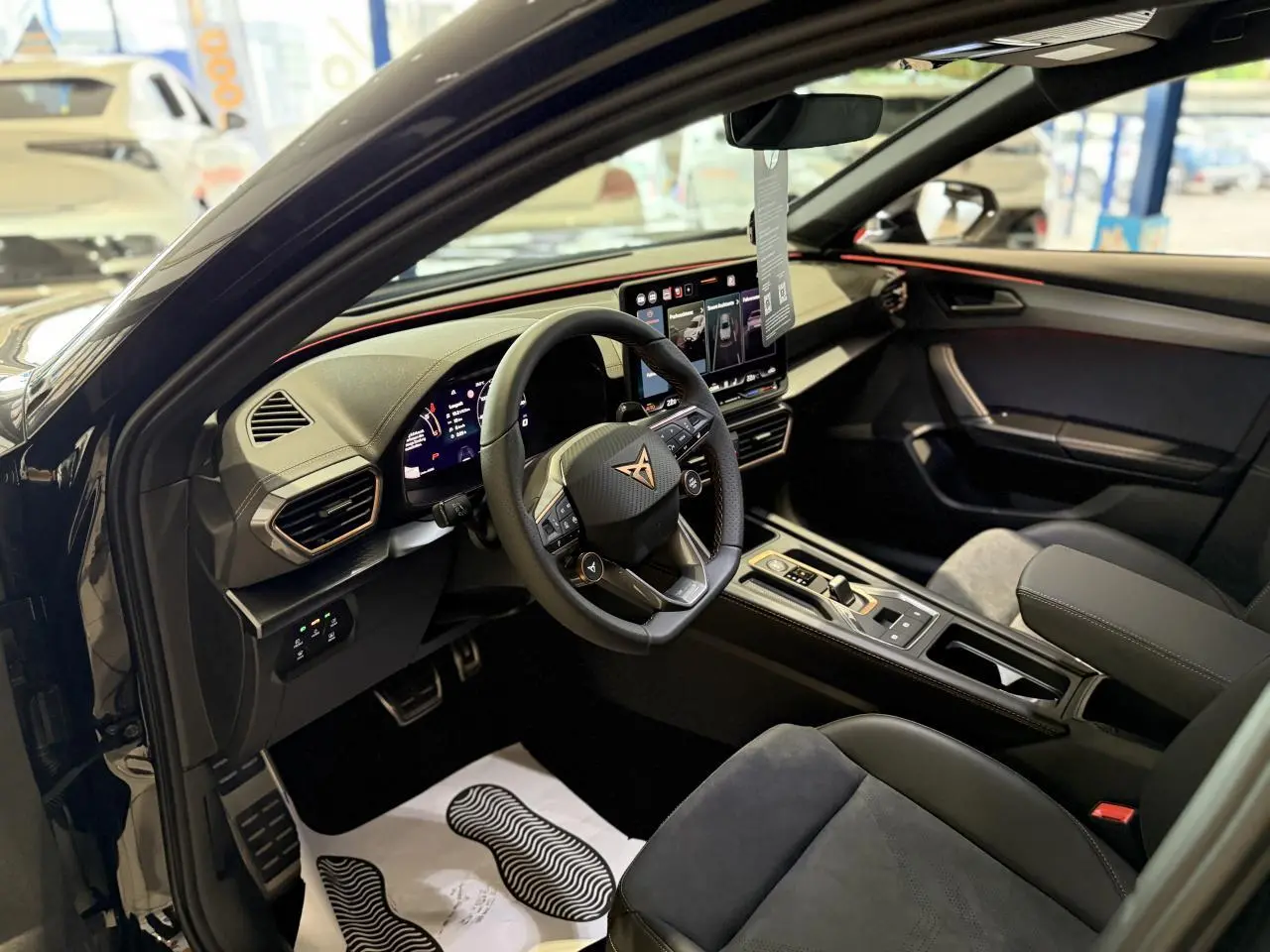 Intérieur du CUPRA Formentor 2025 vu côté conducteur, avec sièges suédine noir et tableau de bord moderne à écran tactile.