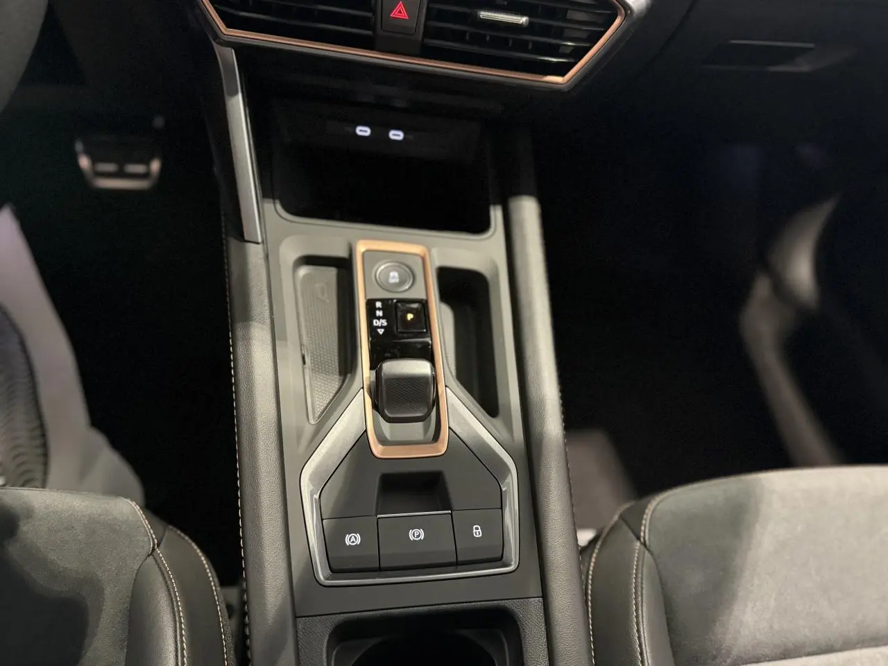 Vue plongeante sur la console centrale noire du CUPRA Formentor 2025 avec levier de vitesses et surpiqûres cuivrées.