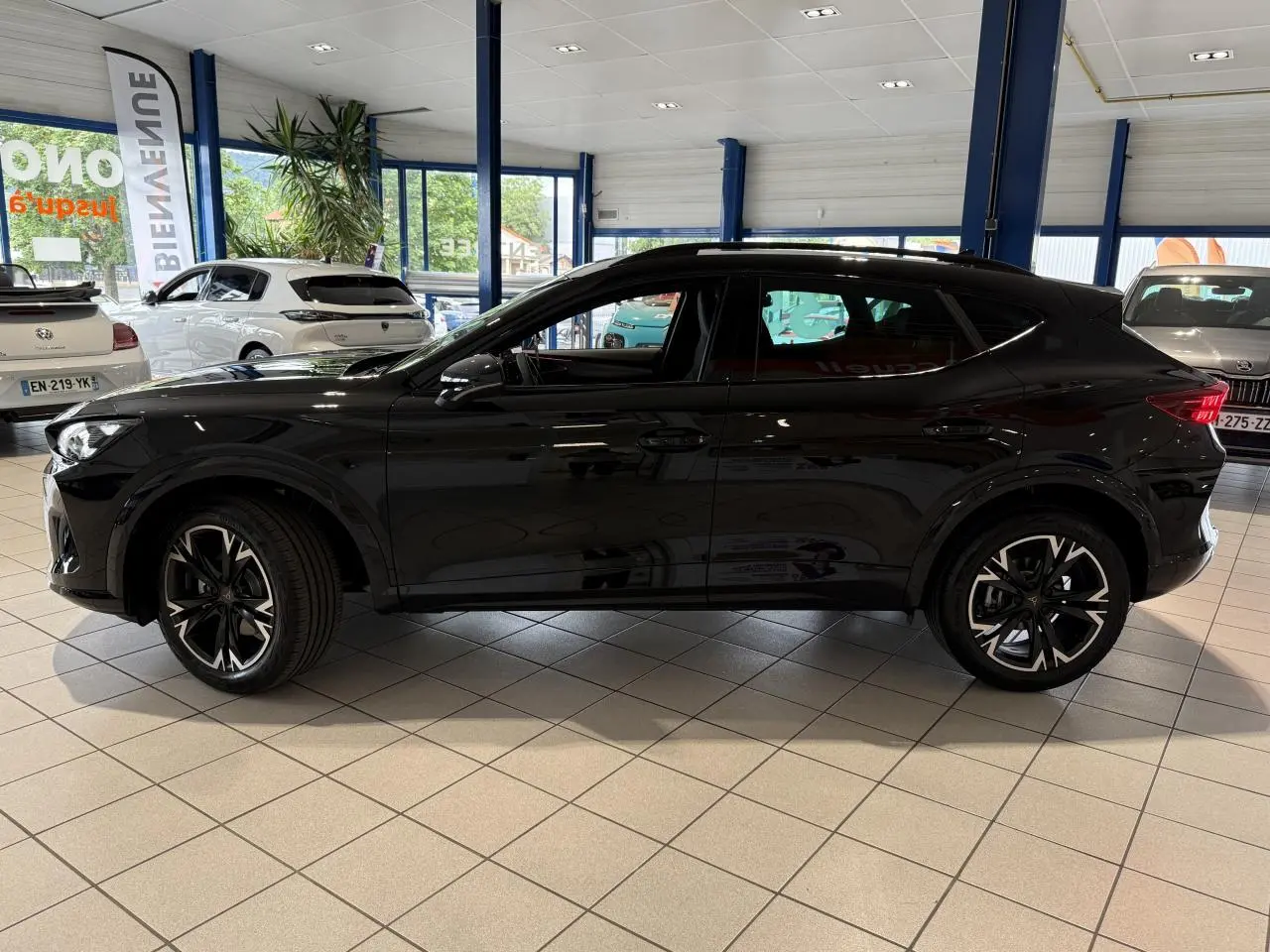 Profil côté gauche d'un CUPRA Formentor noir Night 2025 en showroom avec jantes alliage 18 pouces noires et détails sportifs.