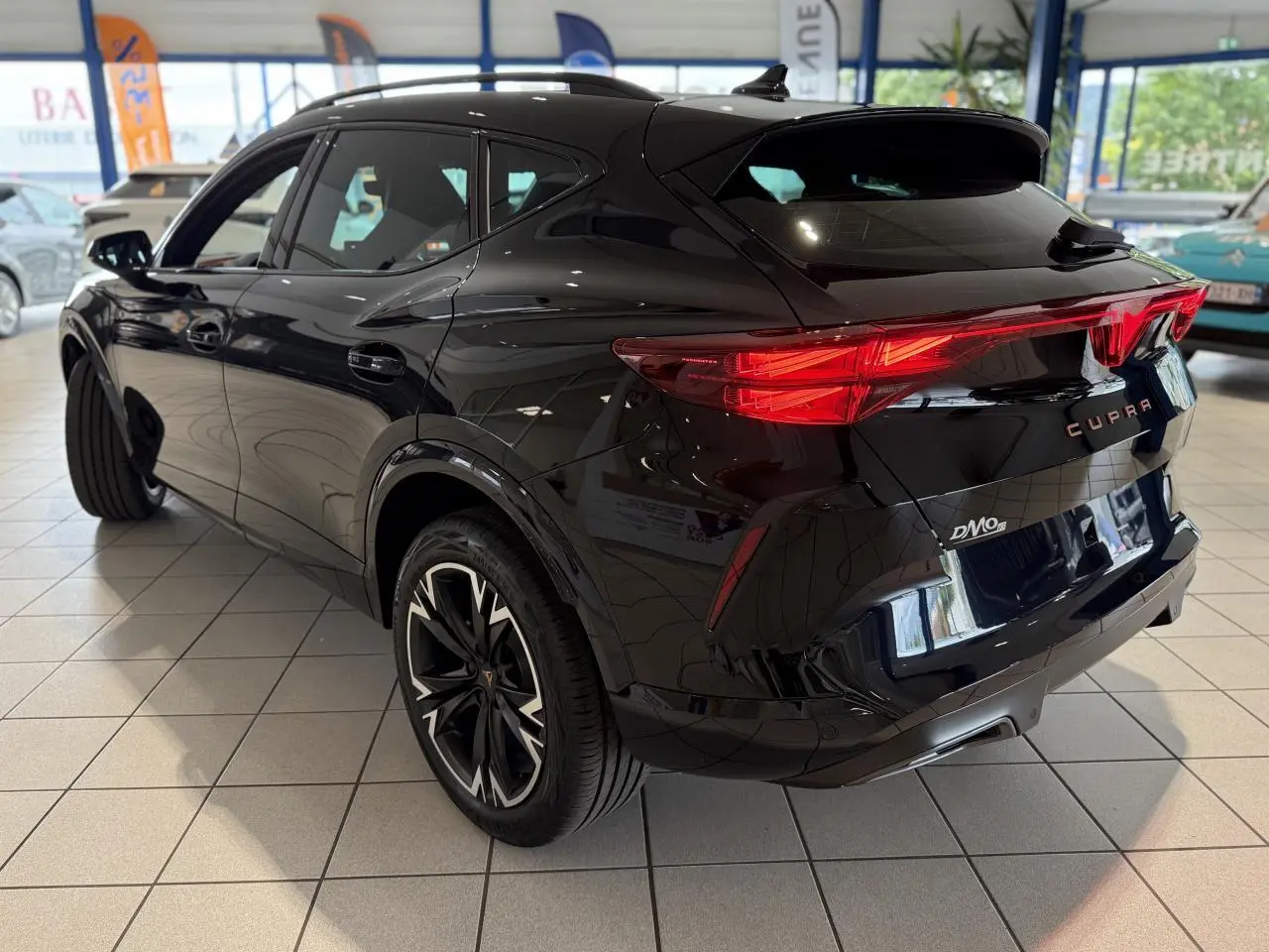 Vue 3/4 arrière droite du CUPRA Formentor noir Night avec feux arrière Tri-LED et jantes alliage 18 pouces.