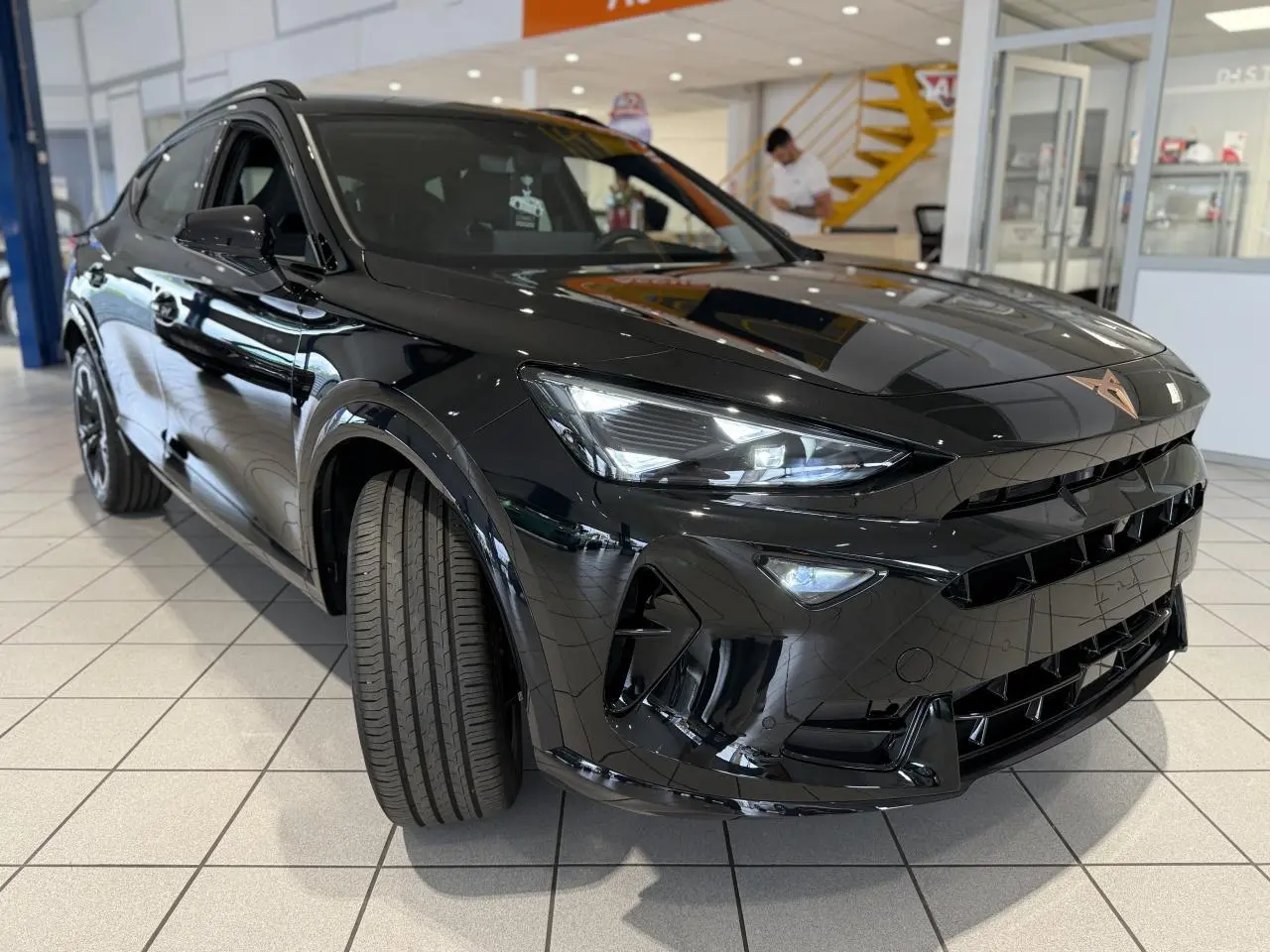 Vue 3/4 avant du CUPRA Formentor noir Night avec ses phares LED et logo Cupra cuivré sur calandre.