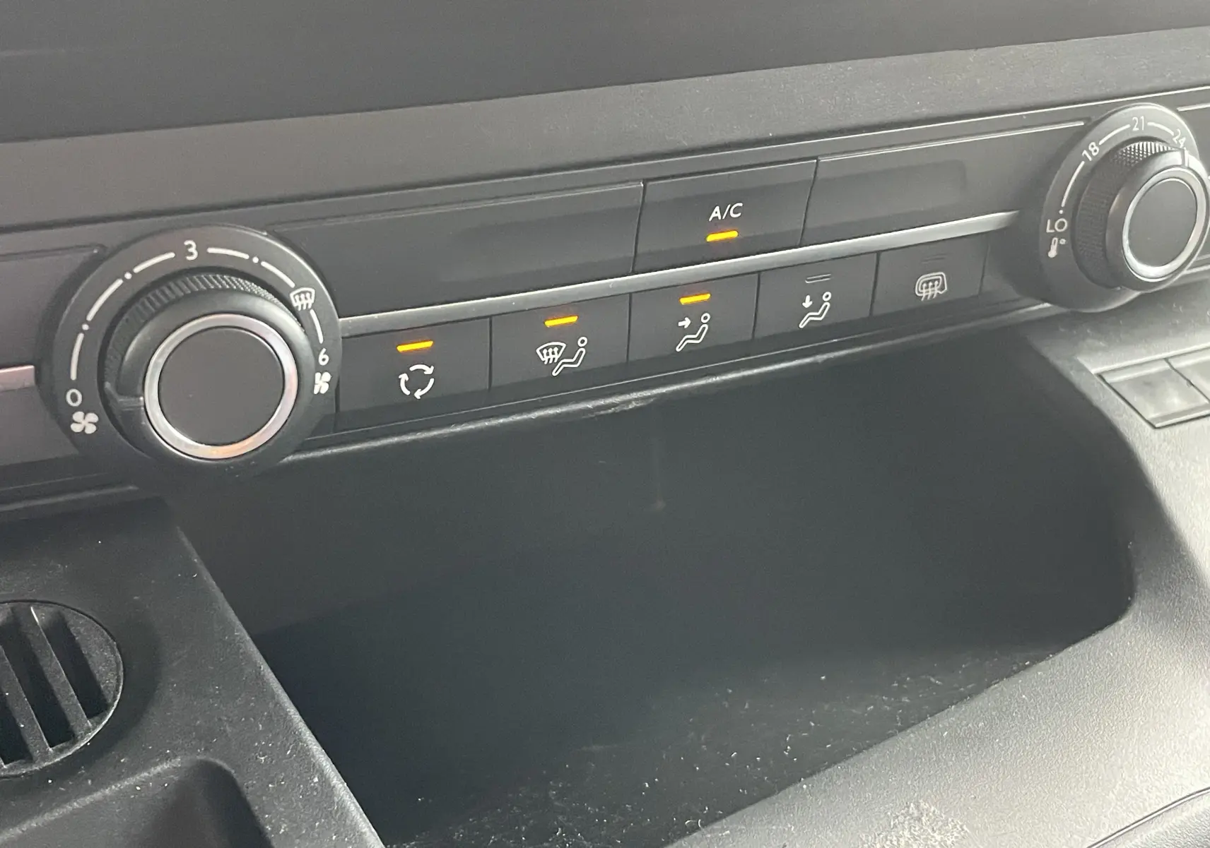 Panneau de commande de climatisation avec boutons allumés dans l'habitacle gris noir du Citroën Berlingo blanc 2018.