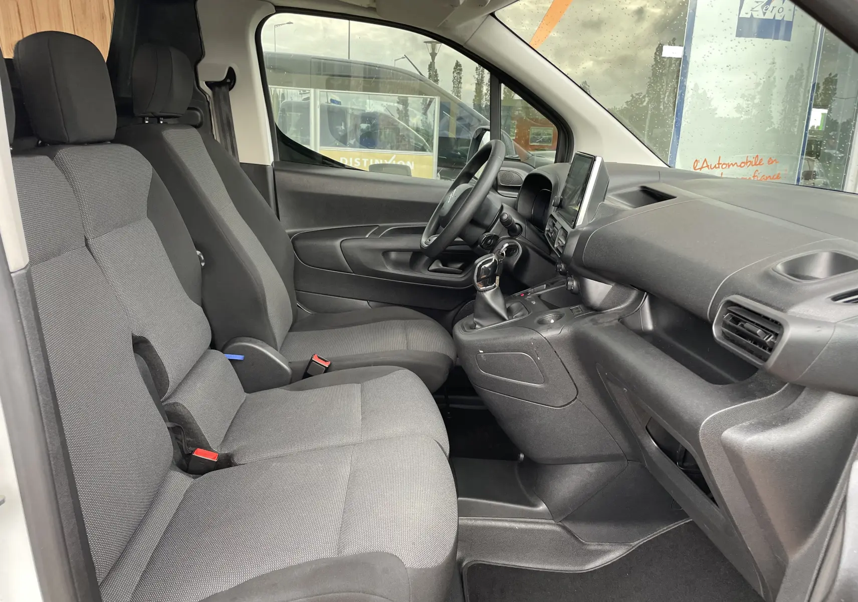 Intérieur du Citroën Berlingo 1.5 BlueHDi 2018 vu côté conducteur, sièges gris et tableau de bord noir.