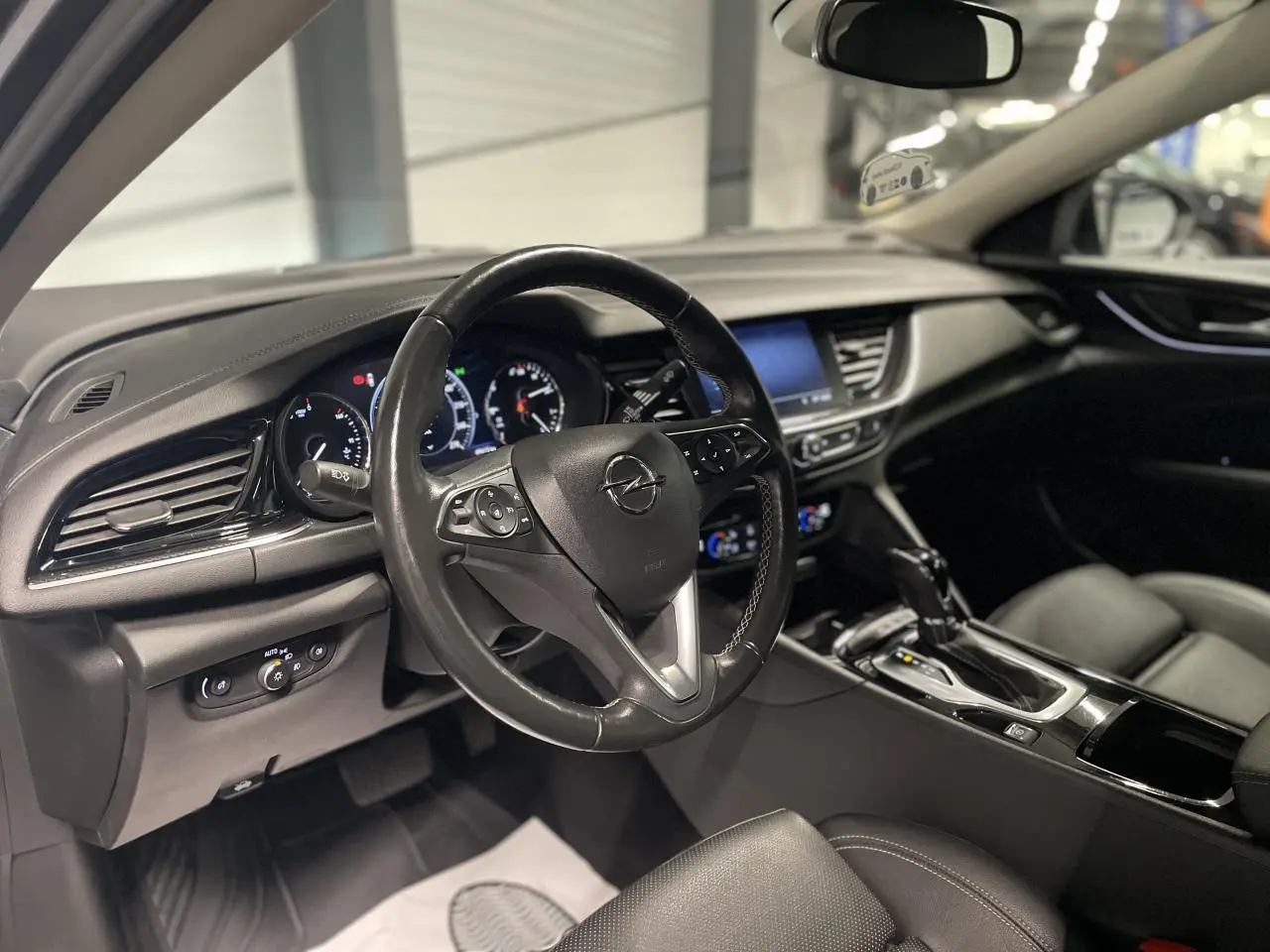 Intérieur noir de l’Opel Insignia Grand Sport 2021, vue côté conducteur sur le volant cuir multifonctions et console centrale.
