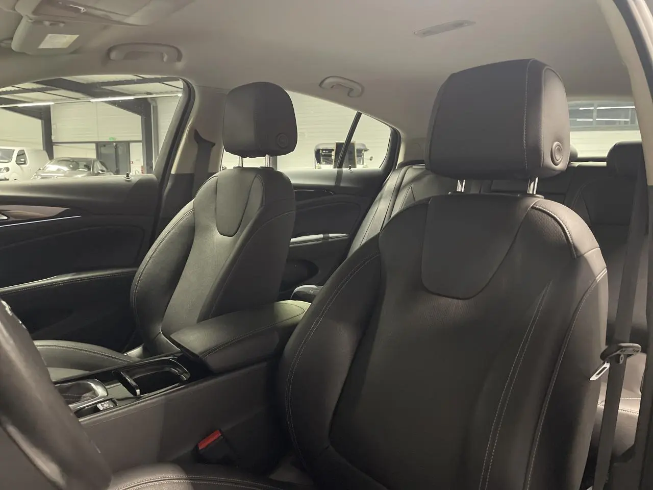 Intérieur de l’Opel Insignia Grand Sport 2021, vue côté droit sur les sièges en cuir noir avec accoudoir central.
