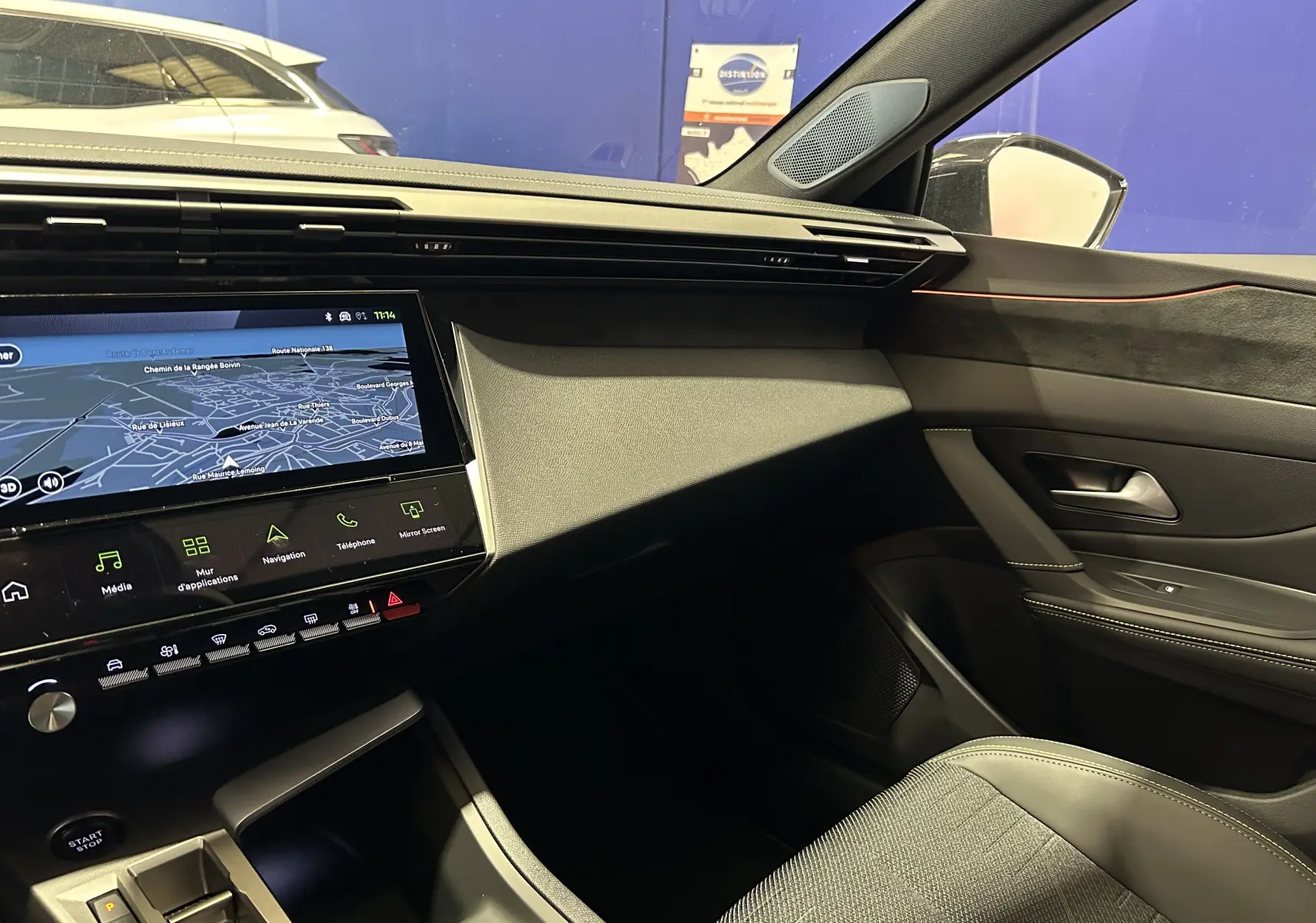 Vue intérieure côté passager du Peugeot 308 III Ph.2 GT avec tableau de bord noir et écran tactile de navigation.