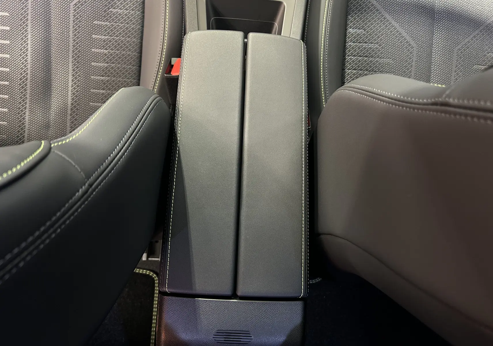 Vue plongeante sur l'accoudoir central en cuir noir avec surpiqûres blanches entre les sièges avant du Peugeot 308 2026.