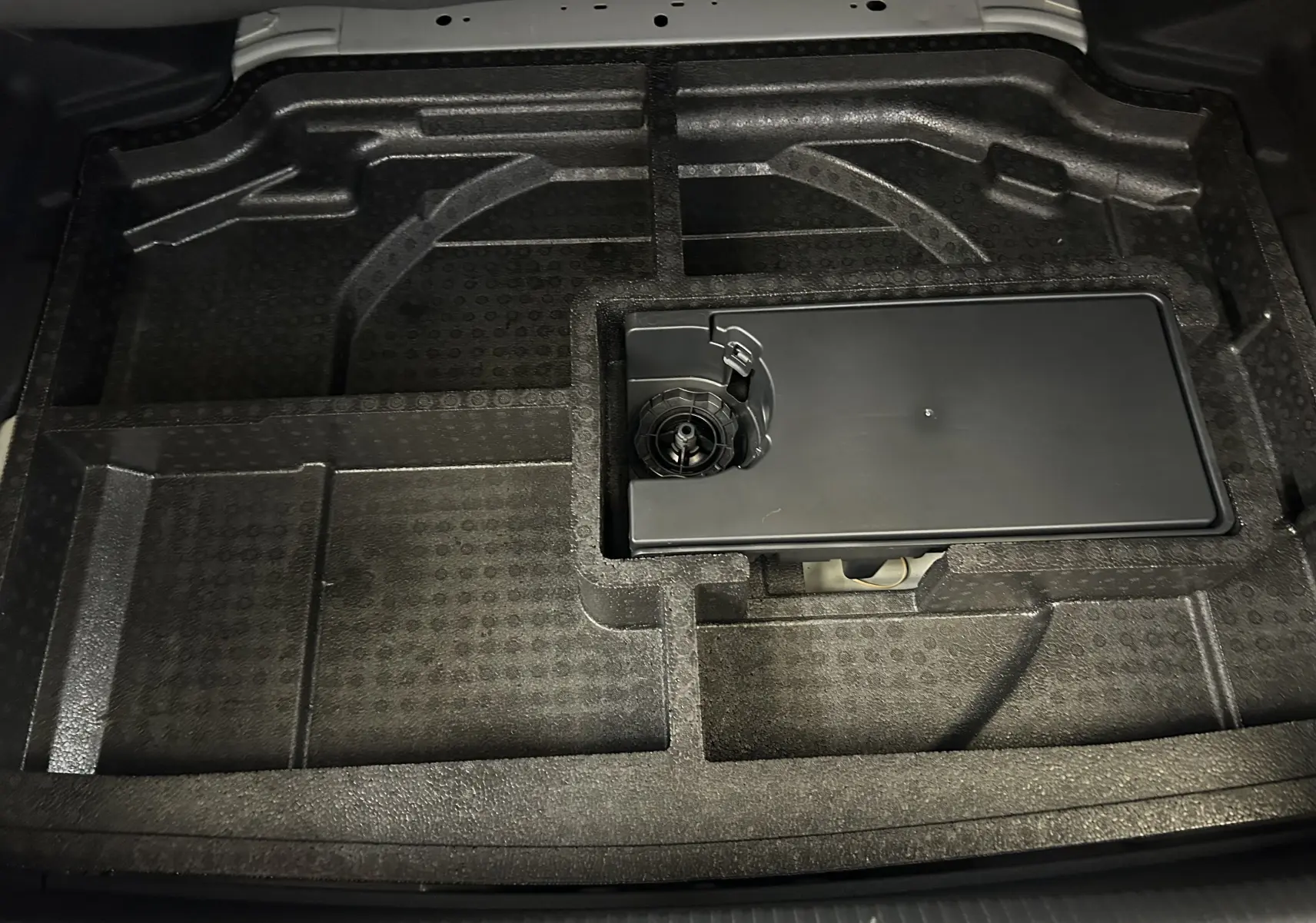 Rangement en mousse noire sous le plancher de coffre du Peugeot 308 III Ph.2 GT BlueHDI 130 EAT8, vue de dessus.