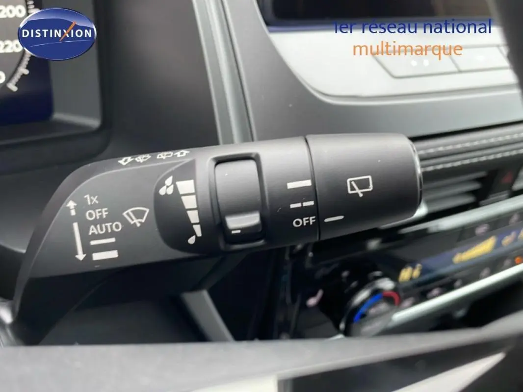 Gros plan sur la commande des essuie-glaces du Nissan Qashqai blanc 2025, intérieur moderne avec tableau de bord visible.