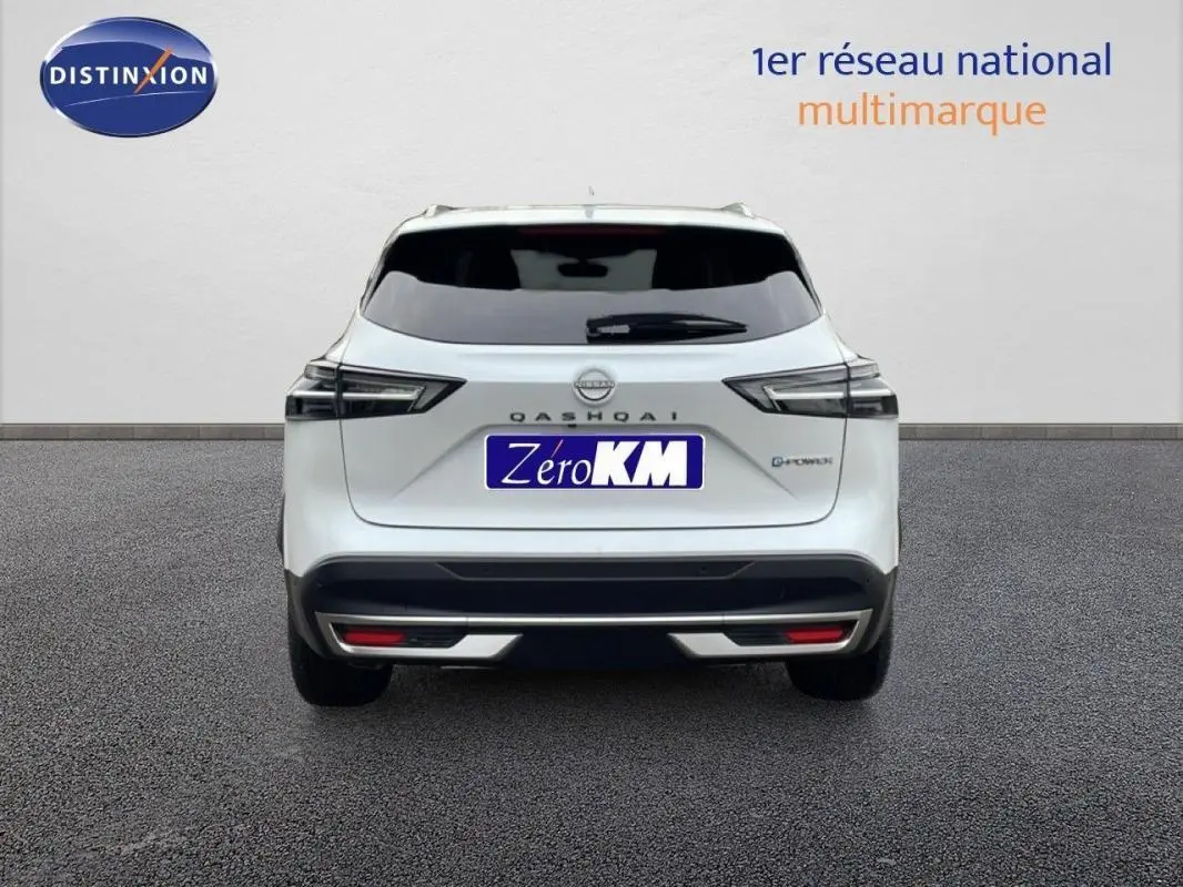 Vue arrière d'un Nissan Qashqai blanc 2025 avec feux LED et badge E-POWER, stationné sur sol gris.