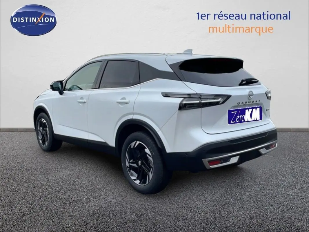 Nissan Qashqai blanc en 3/4 arrière droit, avec jantes aluminium noires et toit noir contrasté.