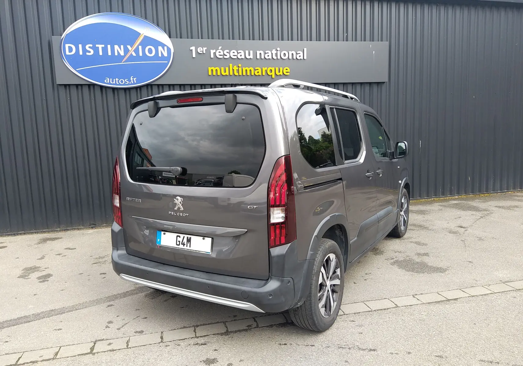 Vue 3/4 arrière droite du Peugeot Rifter gris platinium 2022, avec feux arrière verticaux et vitres teintées.