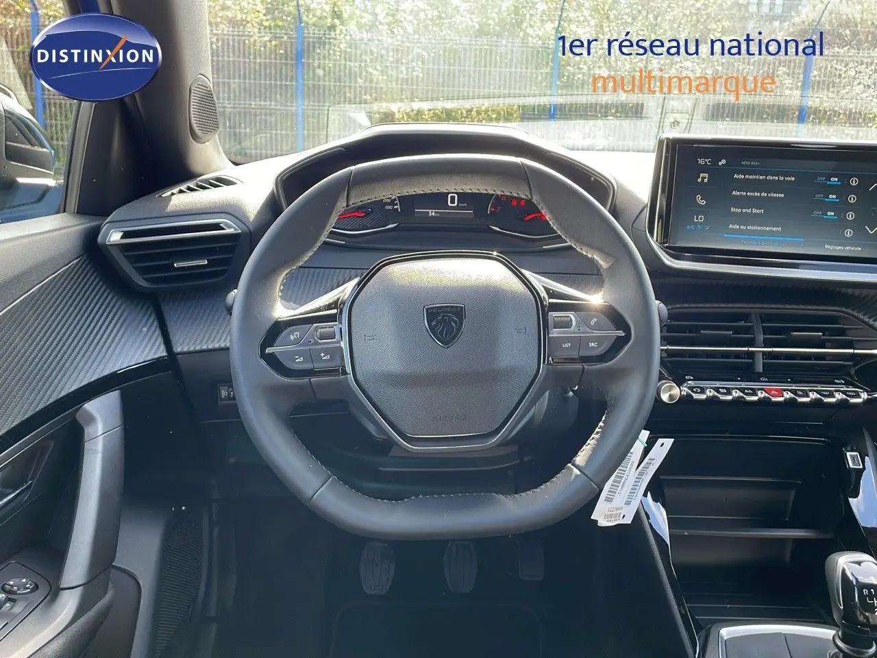 Vue intérieure centrée sur le volant du Peugeot 2008 2024, avec tableau de bord numérique et écran tactile visible.