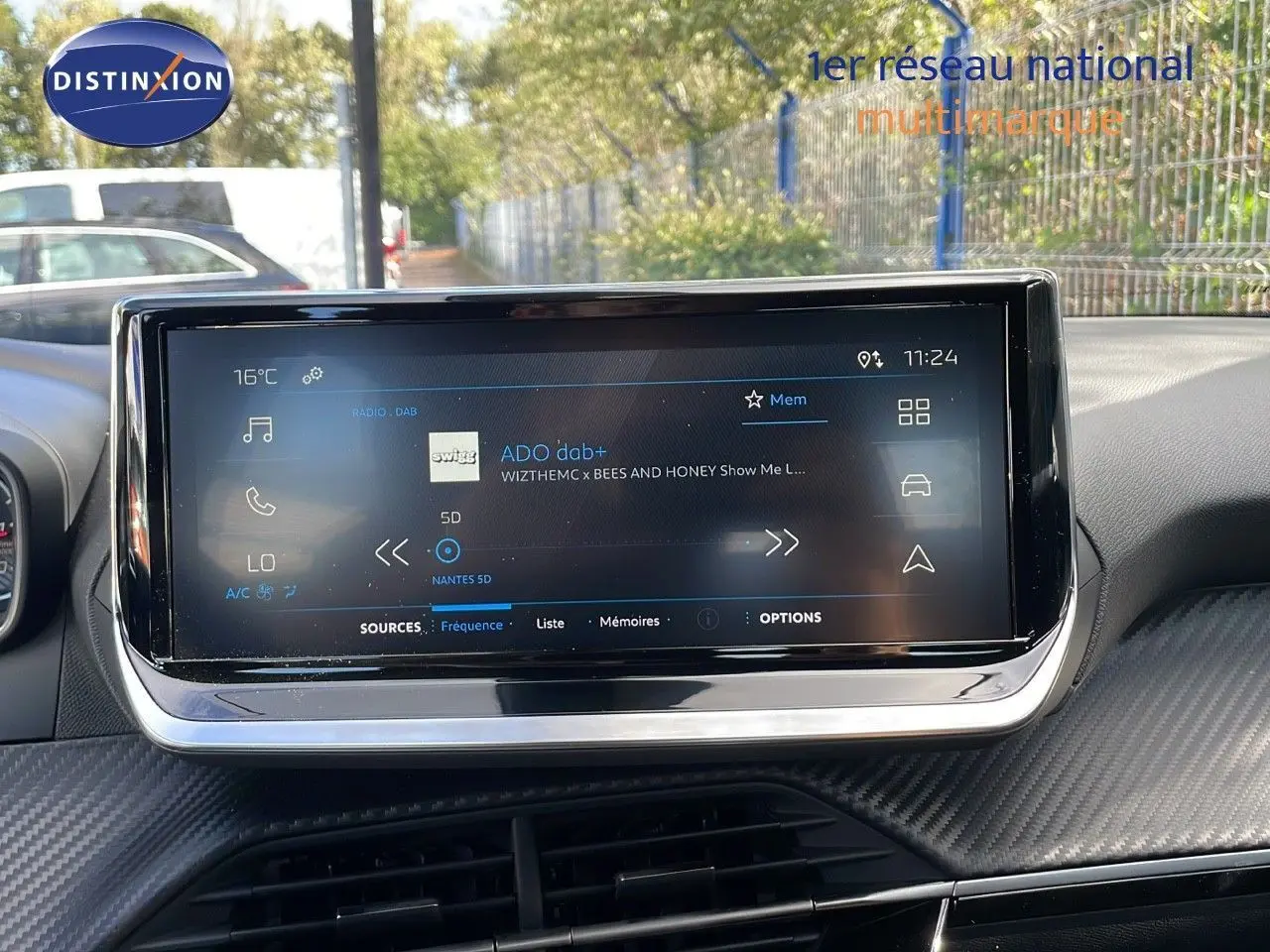 Écran tactile central du tableau de bord du Peugeot 2008 2024, affichant la radio DAB avec interface moderne.