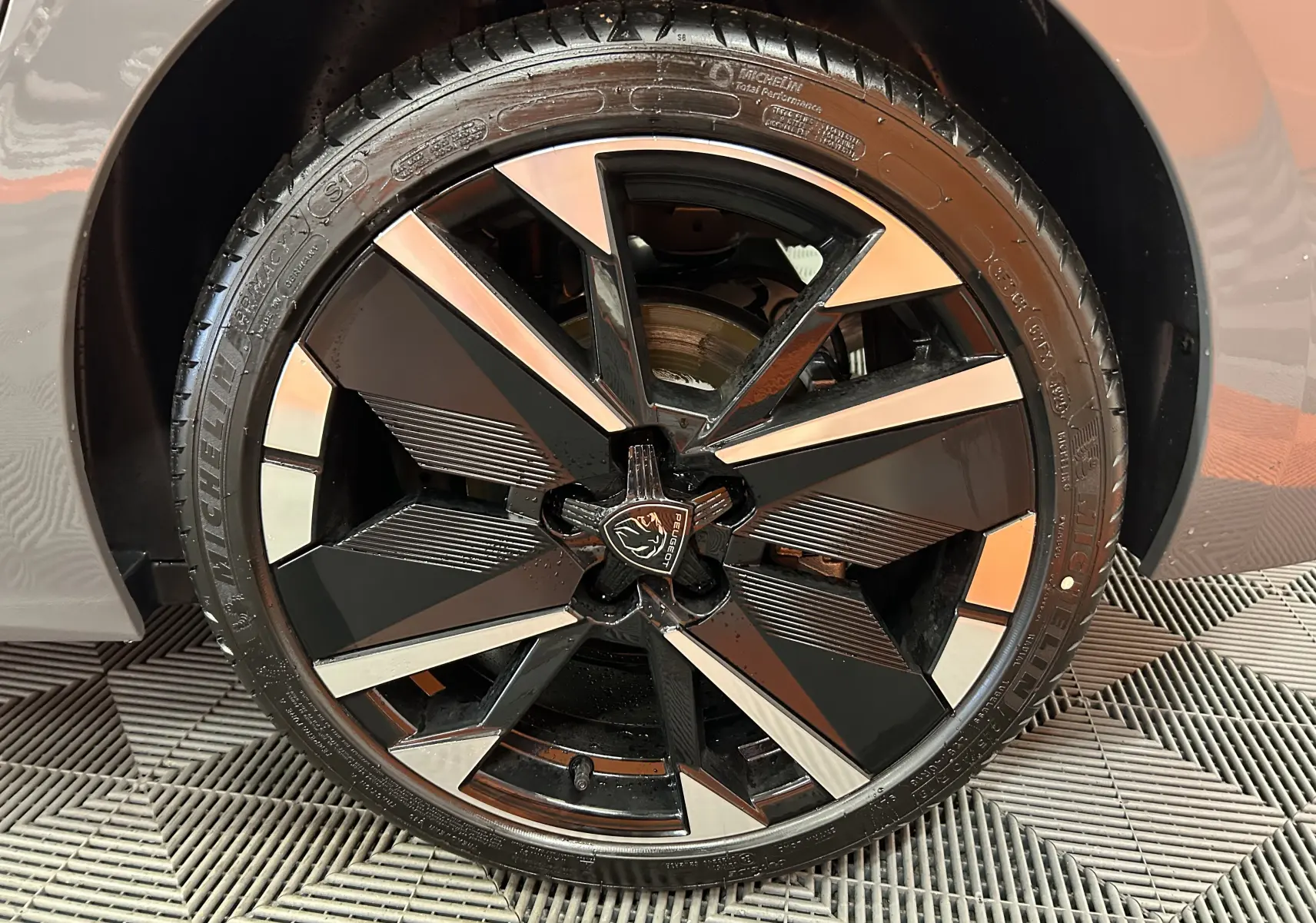 Gros plan sur la jante noire et argentée du côté gauche d’une Peugeot 308 Gris Selenium 2026 hybride.