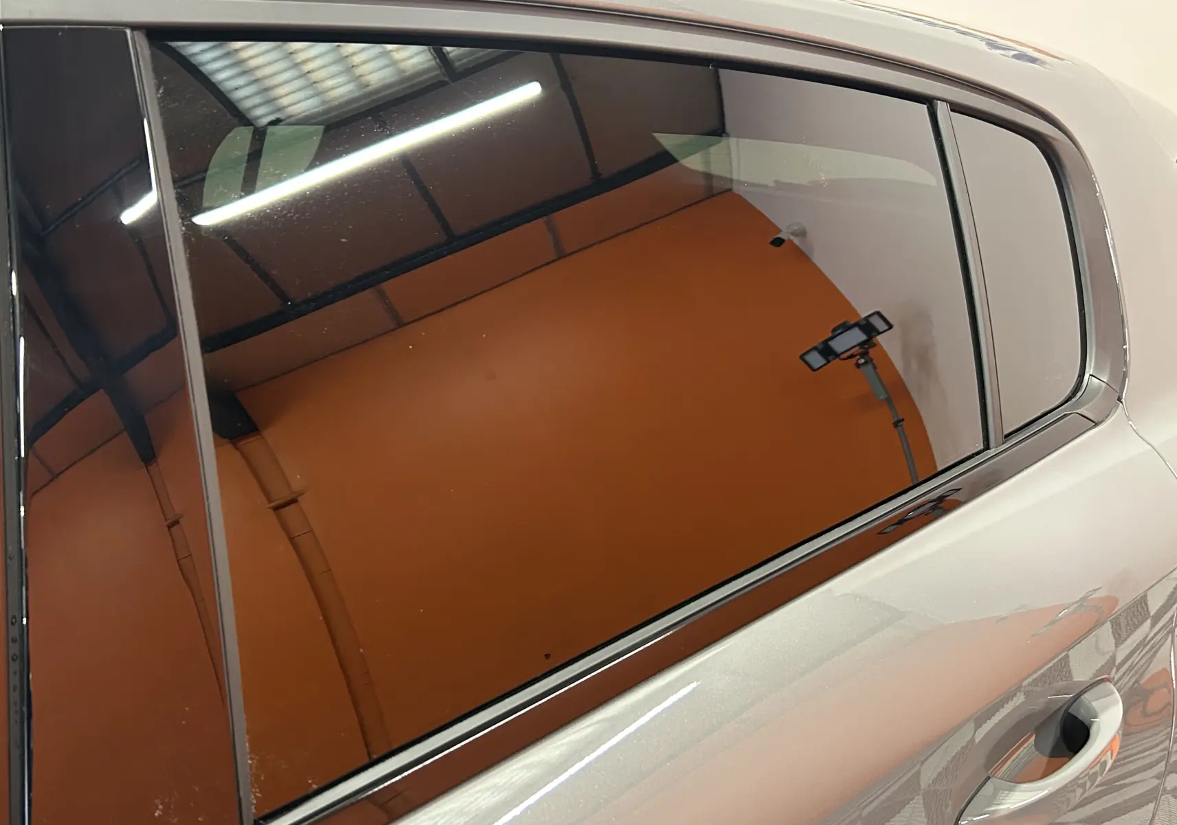 Vue rapprochée sur la porte arrière droite gris Selenium du Peugeot 308 HYBRID 145 GT avec vitrage teinté.