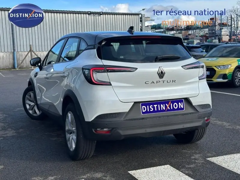 Vue 3/4 arrière d'un Renault Captur blanc nacré avec toit noir et feux arrière LED distinctifs.